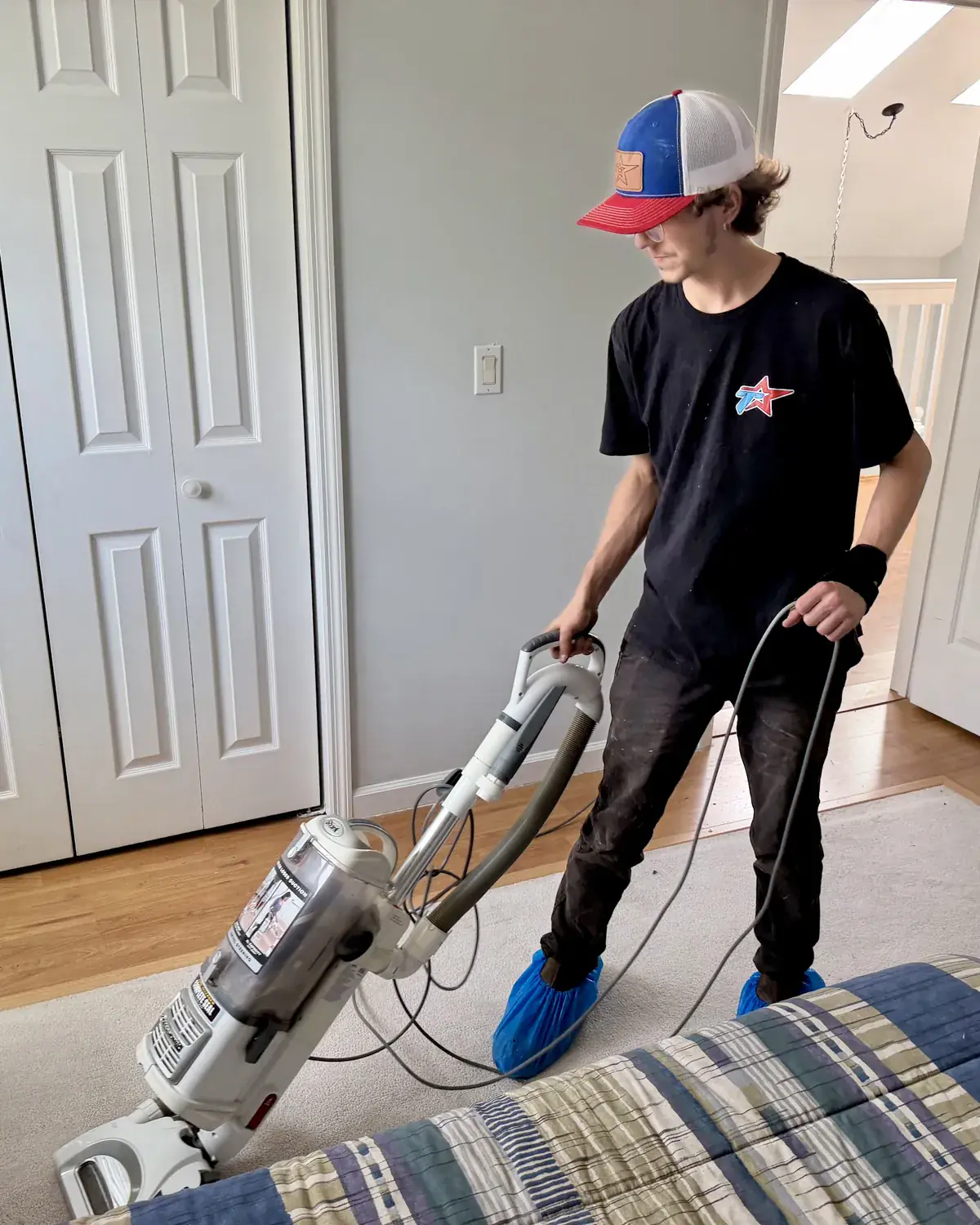 Tramont technician in shoe covers vacuuming after a job