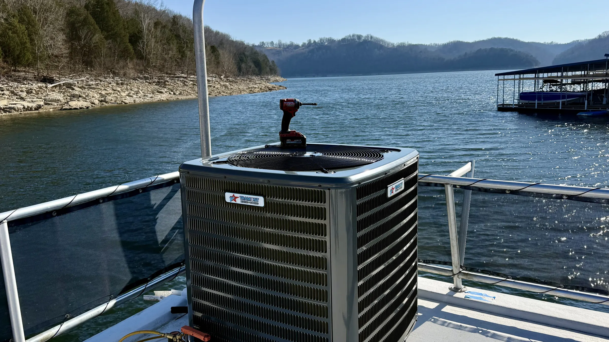 New AC condenser installed on a houseboat deck on the lake